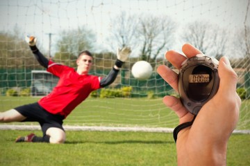 Composite image of coach is holding a stopwatch 