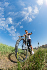 Obraz premium Mountain biking happy sportive girl relax in meadows sunny countryside