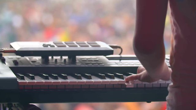 man with synthesizer plays music on the concert