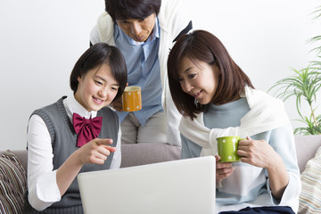 ノートパソコンの画面を見る家族