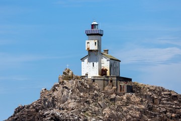 Fototapeta na wymiar Lighthouse on small rock island