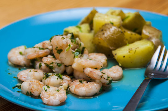 Spanish food: garlic prawns "gambas al ajillo" with potatoes.