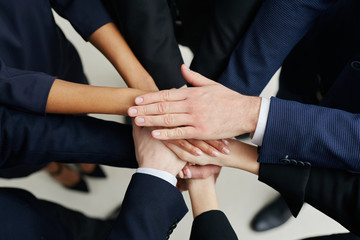 Team work concept. Group of business people joining hands - picture from above