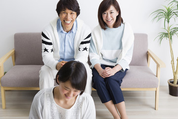 ソファに座る夫婦と娘