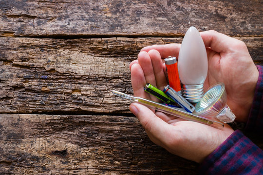 Hazardous Waste In The Hands Of A Man On A Wooden Background