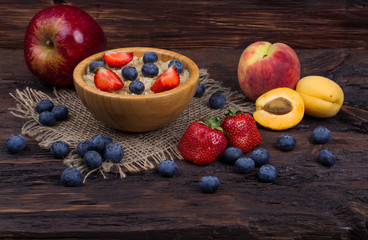 Breakfast with porridge, strawberry, blueberry and apricots