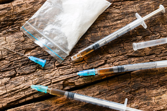 syringes and drugs on wooden background close-up