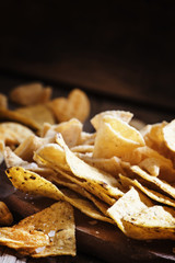 Mexican corn chips on the board, vintage wooden background, sele