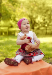 happy little girl in cap playing with Teddy bear