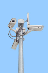Group of security cameras (CCTV) or surveillance camera on pole isolated on blue background.