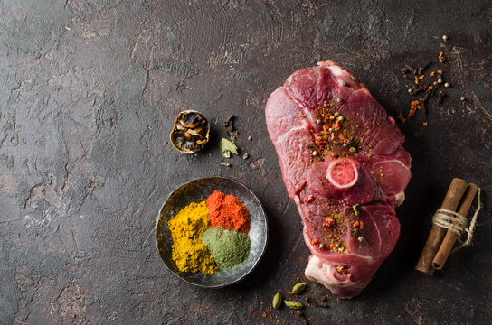 Raw Mutton meat with east spice on dark background.