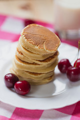 Tasty Pancake with fresh cherries on a white plate. American breakfast