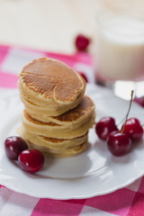 Fototapeta na wymiar Tasty Pancake with fresh cherries on a white plate. American breakfast