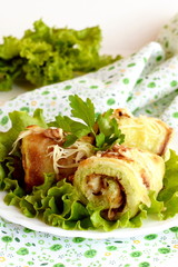 Rustic fried stuffed zucchini with cheese, walnuts and fresh parsley decorated with green lettuce on a plate and on a napkin. Zucchini snack recipe. Vegetarian holiday appetizer