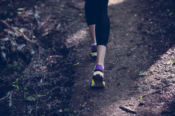 Beautiful and attractive legs of woman running on the forest, the mountain. Black, yellow and purple colors.