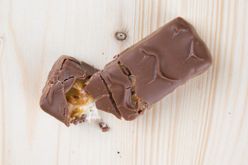 Chocolate bar with caramel and coffee filling on wooden table