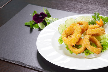 fried calamari rings on dark plate