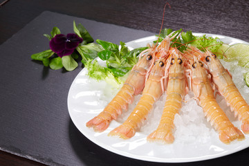 shrimps on stone plate over wooden table