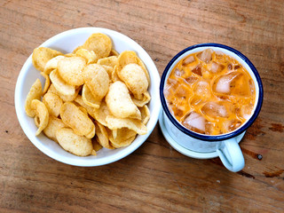 Thai tea and Prawn cracker on wood