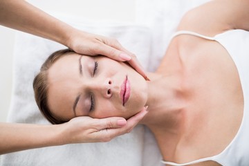 Cropped hands of masseur massaging woman