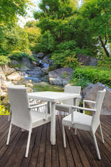 Obraz premium White dining table on wooden floor and waterfall background