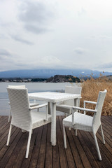 Fototapeta na wymiar White dining table on wooden floor and Fuji mountain background