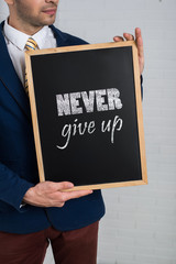 Man in a suit with a black board in his hands on a white backgro