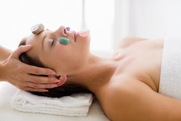 Obraz na płótnie Canvas Masseur giving facial stone massage to woman
