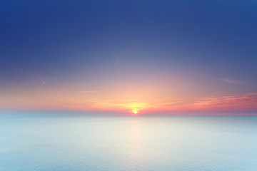 Sonne versinkt im Meer am Horizont