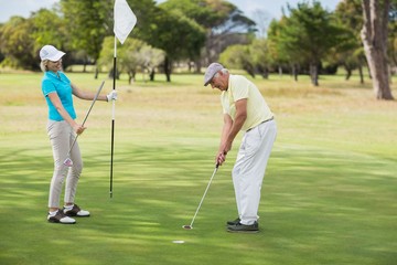 Fototapeta premium Mature man and woman playing golf 