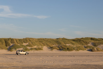 Car driving on sand beach in Jutland, Denmark