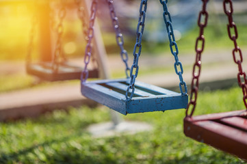 Empty chain swing in playground. vintage filter
