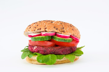 Vegan beetroot burger with lamb's lettuce, tomato, cucumber and radish isolated on white background

