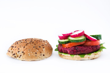 Vegan beetroot burger with lamb's lettuce, tomato, cucumber and radish isolated on white background

