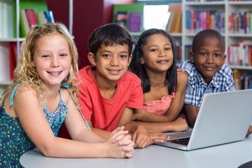Happy classmates with laptop