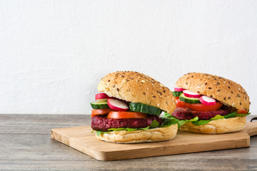Veggie beet burgers on a rustic wooden table and white wall


