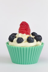 frosted cupcake with colorful fruits