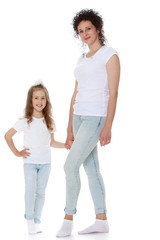Stylish mom and daughter in matching jeans and white shirts - Isolated on white background