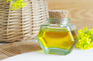 Small bottle of natural cosmetic oil and wooden hair comb