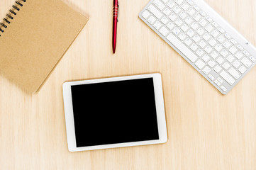 Top view office table with pen and notebook and tablet or smartphone
