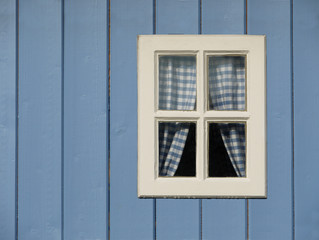 Fenster in einer blauen Holzh&uuml;tte