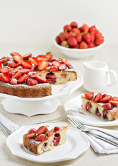 Homemade strawberry cake on a white cake stand.