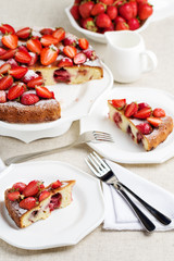 Homemade strawberry cake on a white cake stand.