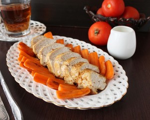 Roast chicken fillet with baby carrots.