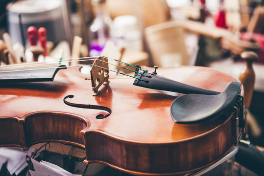 Close up of violin, luthier workshop in background