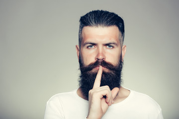 Bearded man with hush gesture