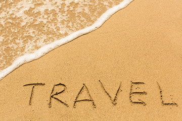 Travel - word drawn on the sand beach with the soft wave.