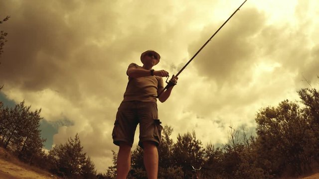 Retro style fisherman catching fish. Trout fishing on mountain river. Underwater video through water level. 