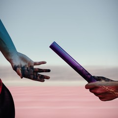 Composite image of athlete passing a baton to the partner