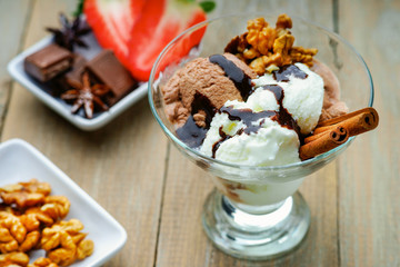 Ice cream sundae, chocolate, walnuts and sliced strawberry 